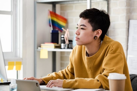 LGBTQIA+ member working on a computer
